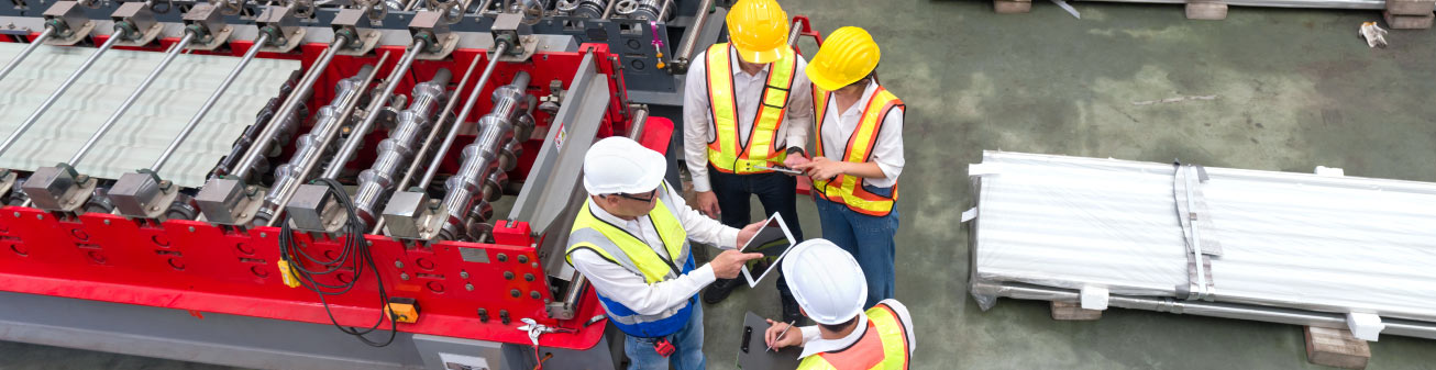 Warehouse employees discussing over a tablet.