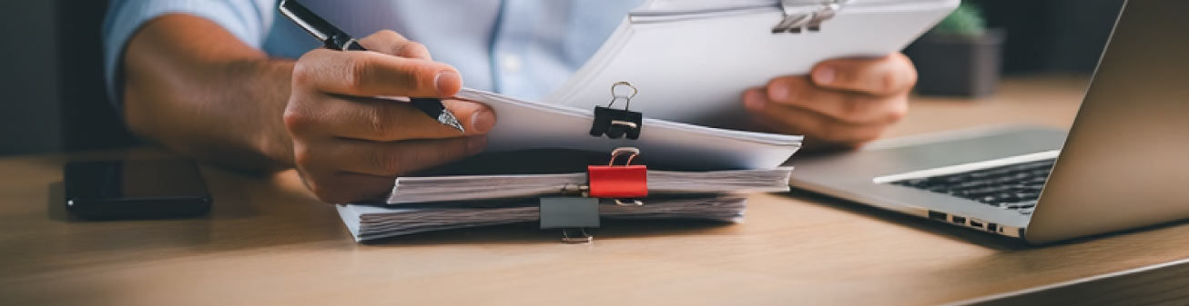 Person reading a stack of papers.