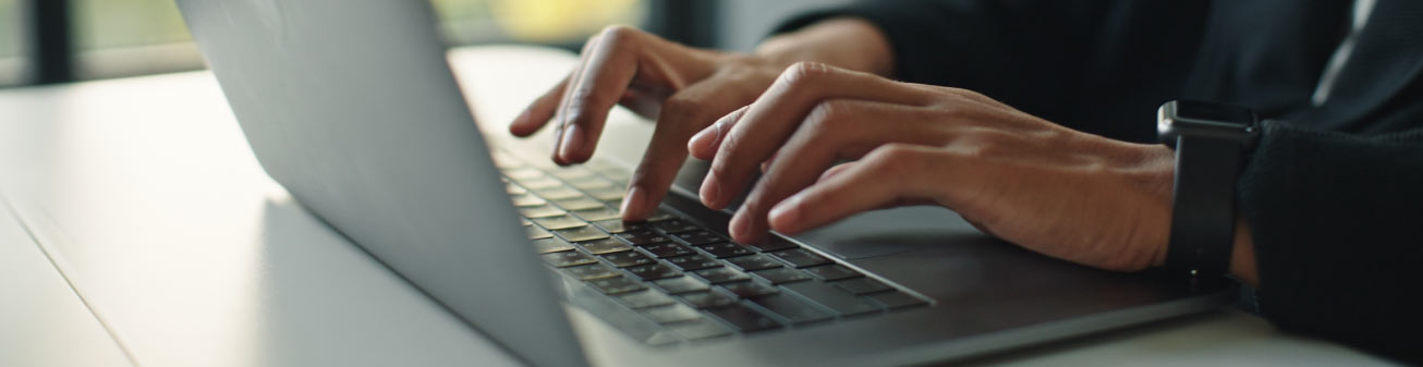 Image of a person typing on a laptop.