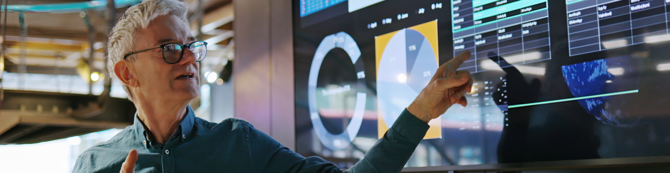 Employee pointing at statistics on a screen