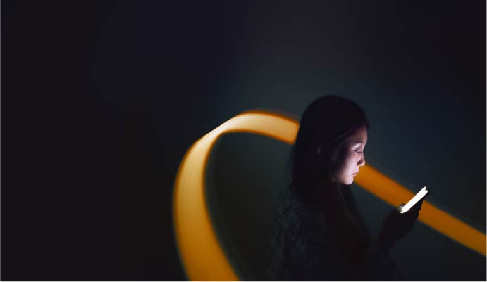 Woman looking down at phone with decorative background.