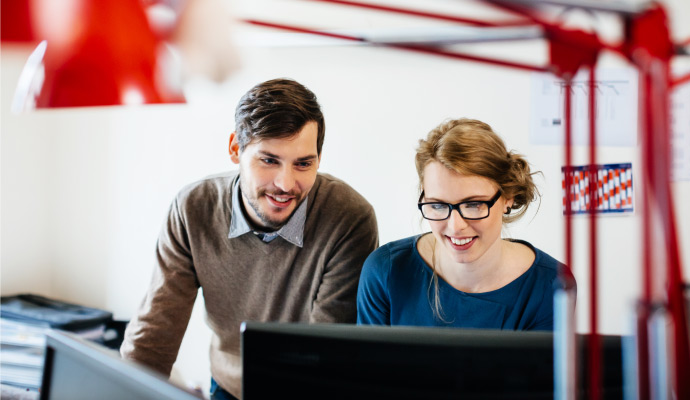 Two people sitting at a computer.