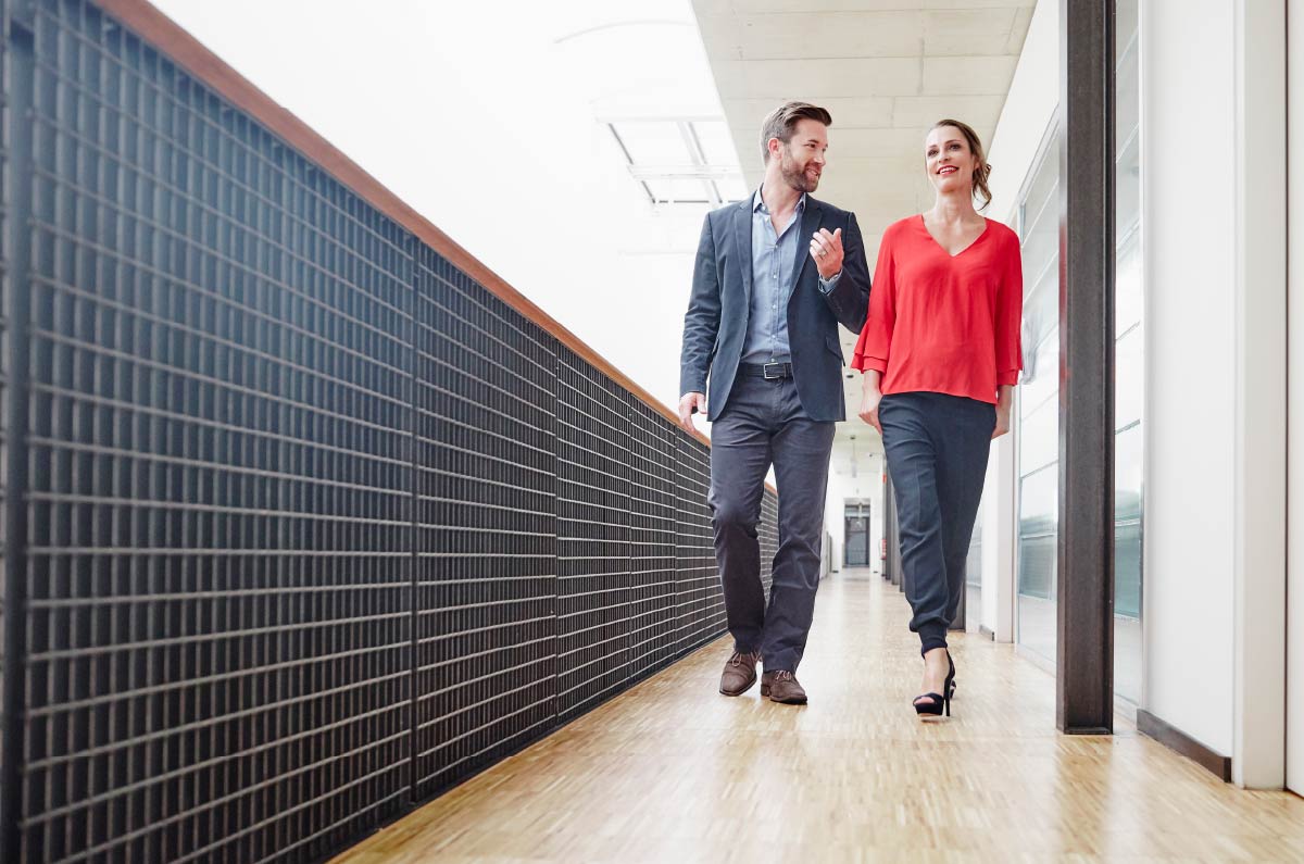 Two people walking down a hallway