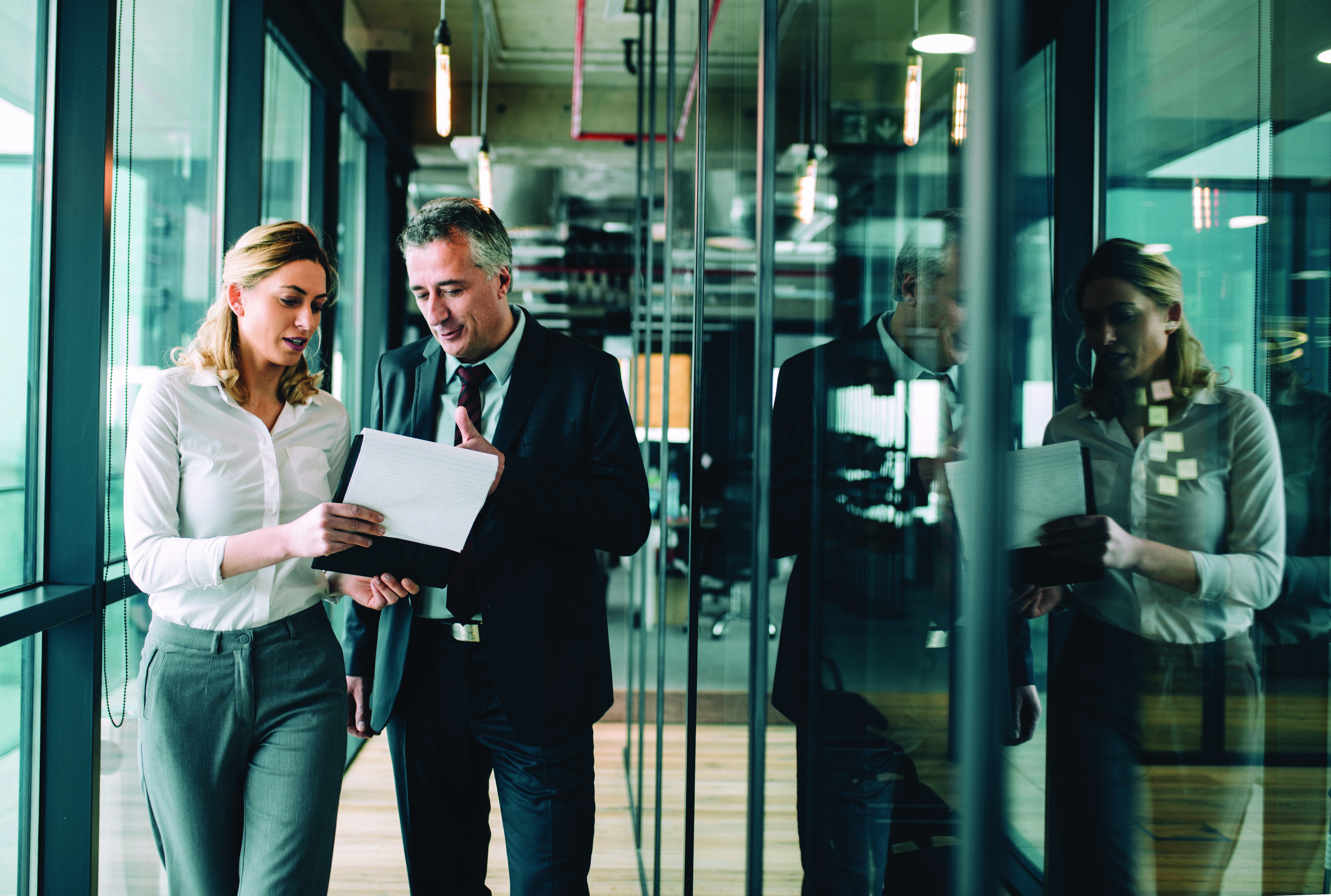 Two experienced professionals reviewing internal audit documents