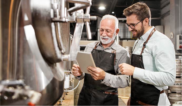 two men meet with a tablet in distillery
